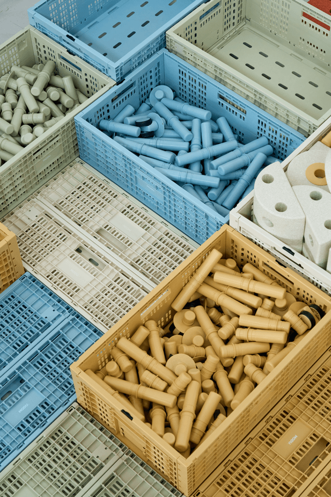 View from above of blue, yellow, green and cream MODU crates arranged closely together, some holding matching connectors and blocks.