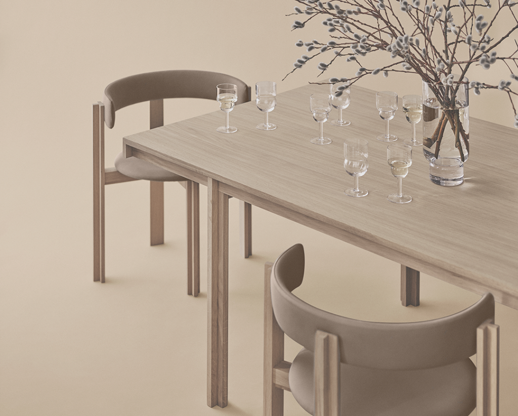 Wooden Karakter Principal dining table and chairs with clear glassware and branches in a vase.