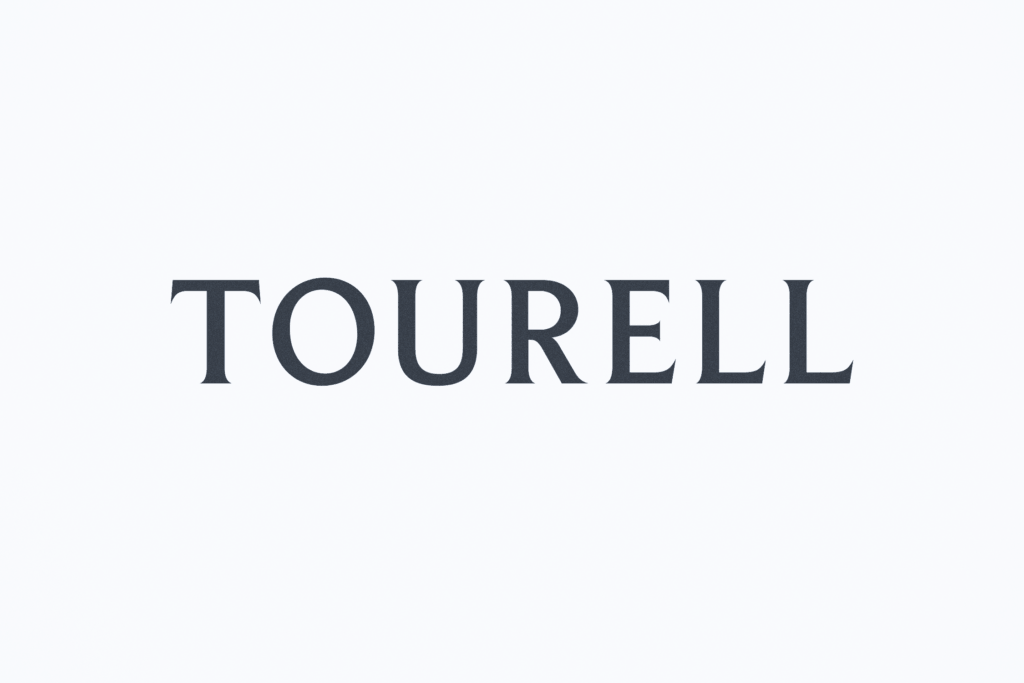 Tourell wordmark in dark uppercase lettering with sharp, flared ends, centred on a pale background.