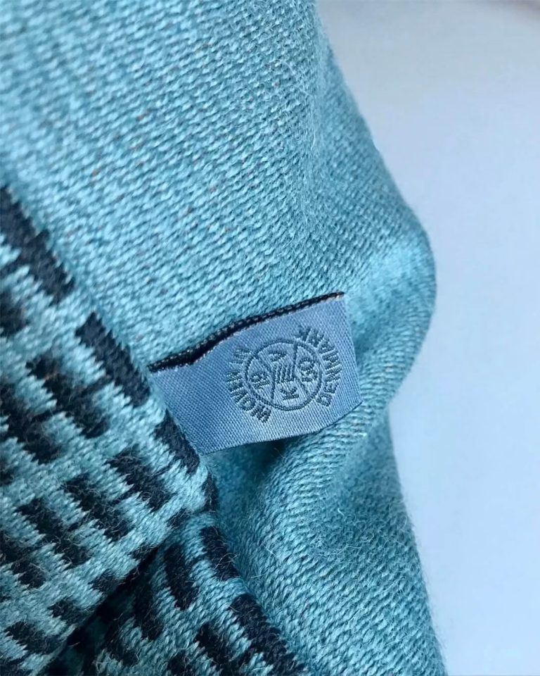 Kjellerup Væveri identity with a stamped wordmark inspired by a single thread